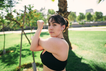 a beautiful white woman with brown hair exercises her arms to be ready for physical activity                  