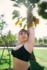 a beautiful white woman with brown hair exercises her arms to be ready for physical activity                  