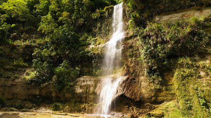 Fototapeta na wymiar Beautiful waterfall in green forest, top view. Tropical Can-umantad Falls in mountain jungle. Bohol, Philippines. Waterfall in the tropical forest.