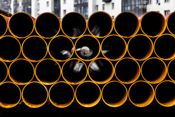 Pile of round industrial material polyethylene thermoplastic pipes on a construction site
