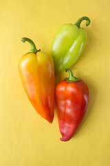 three different bell peppers on yellow . High quality photo