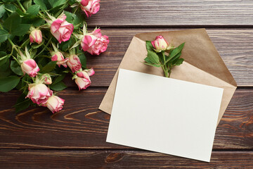 Greeting card with roses on dark wooden background, mockup with copy space