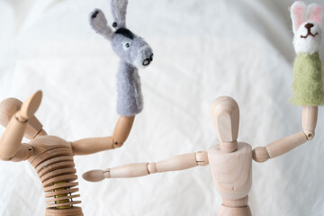 two artist's manikins (mannikins) posing with donkey and rabbit finger puppets