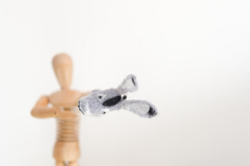 artist's mannikin or manikin posing with finger puppet - focus on donkey or mule - arm stretch forward