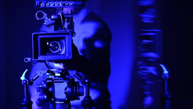 Camera Operator Taking Video Shot Inside Blue Illuminated Room