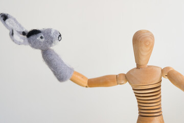 artist's mannikin or manikin posing with mule or donkey finger puppet - arm stretched out