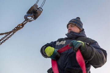 A portrait of an installer in a blue jacket with a ribbon rag sling