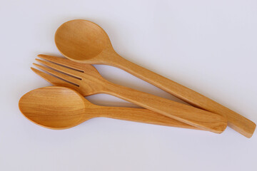 Wooden spoons and fork kitchenware isolated on white background closeup. 