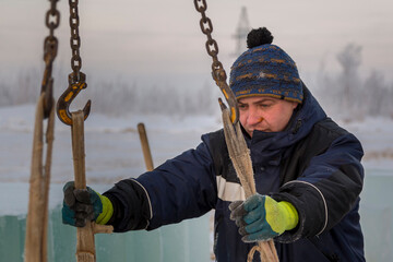 Portrait of a fitter in a blue jacket at a construction site - 432256468