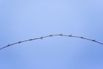 barbed wire against a blue sky background