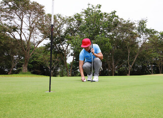 Obraz premium Male golfer hold and put the golf ball on mark point, Hand putting golf ball on tee in golf course