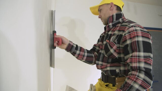 Caucasian Construction Worker Patching Drywall Walls