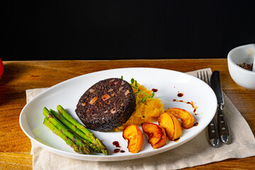 Black pudding with green asparagus and fried apple