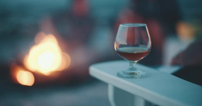 glass of whiskey infant of bornfire at the beach