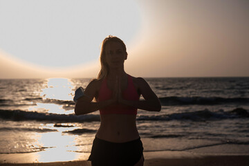 One blonde girl in pink top on seashore at sunset goes in for sports. Being active in  fresh air is very beneficial to your health. Get active and stay fit in shape coronavirus time. Outdoors.