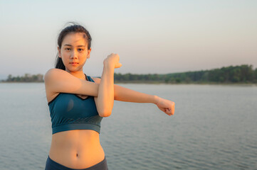 Chanthaburi - Thailand 13 February 2021 : Young beautiful Asian woman in sports outfits doing stretching before workout outdoor in the park in the morning to get a healthy lifestyle. Healthy young wom