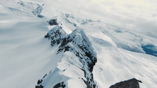 Mountain tops covered in snow in dangerous fast fvp drone view