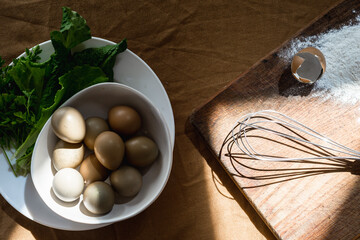 Set for preparing homemade food from eggs, flour and fresh herbs with a tool for beating eggs whisk. High quality photo