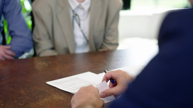 Financial advisor attorney explaining contractual details to couple in the blur in a modern office