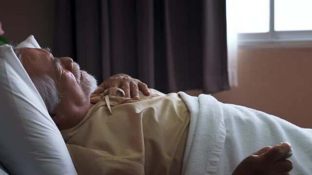 Group of Professional male doctor team help senior man patient unconscious by heart attack on bed in hospital recovery room. Hospital, medical urgency treatment and healthcare service concept