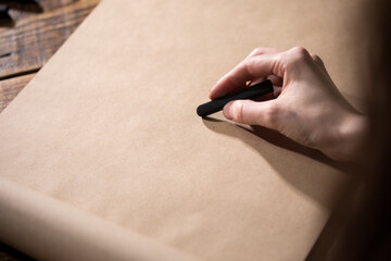 Close-up view of the artist on a blank sheet. The hand holds a pencil and draws. Drawing and creativity concept.