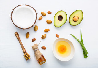 Natural herbal skin care products, top view ingredients coconut,almond, aloe vera, avocado,egg,honey on table concept of the best all natural face moisturizer. Facial treatment preparation background.