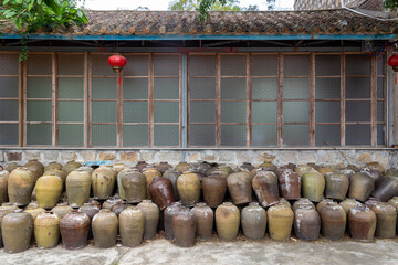 traditional Chinese house with stacked rice wine vessels against the wall