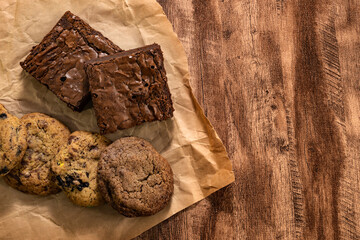 Pieces of fresh brownie on wood table background, top view. Delicious chocolate pie