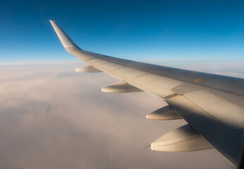 Obraz premium View from passenger window of wing of airplane flying in sky on sunny day. Concept of successful travel