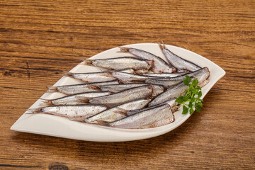 Anchovies in the bowl served basil leaves
