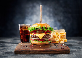 Burger with french fries on a dark background