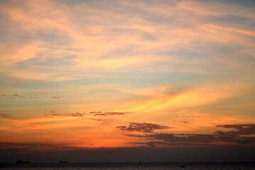 Dramatic sunset. Orange-violet sky. The sun behind the clouds. Landscape.
