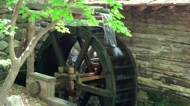 Big Water Wheel as a part of Watermill In A Zen Garden At A Korean Folk Village - medium shot