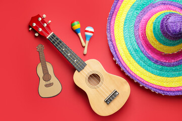 Mexican sombrero, maracas and guitar on color background
