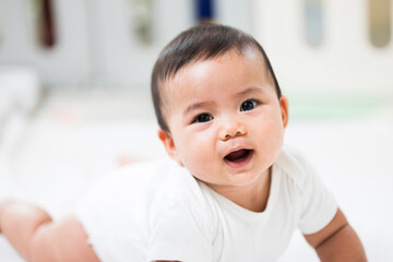 A cute baby wearing a white dress Stay with parents in the house