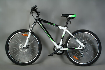 Fototapeta na wymiar Mountain bike on a gray background. A modern bike with disc brakes and an aluminum frame. 