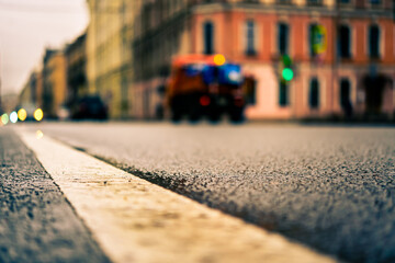 Obraz premium Rainy day in the big city, the headlights of the approaching cars on the road. Close up view from the level of the dividing line