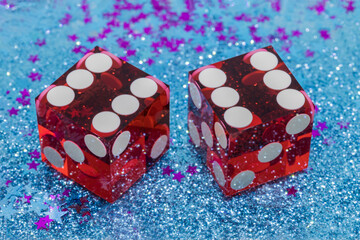 Two red transparent dice on a decorated holiday table. The result is 