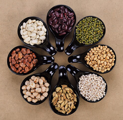 Mix nuts in black bowl on wood background