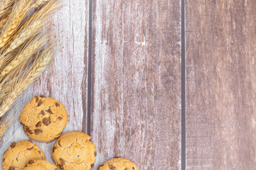 biscuits and dried wheat on wooden background with empty place for text