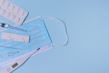 Express COVID-19 test,Schnelltest, medical mask, syringe,thermometer,medicine on a blue...