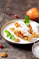 homemade fragrant strudel with apples and cinnamon on a plate on a wooden background with space for text