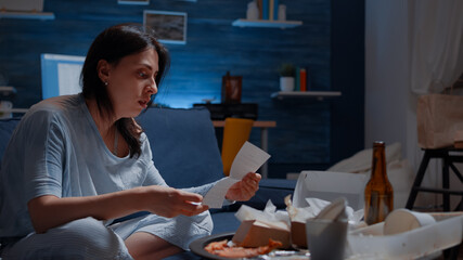 Confused frustrated nevous young woman reading letter, debt notification, bad financial report, money problem, eviction notice. Shocked, worried tenant by warning document for unpaid bank bills