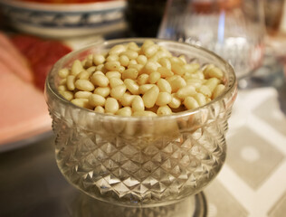 Pile of peeled kernels of cedar nuts in a fluted crystal vase
