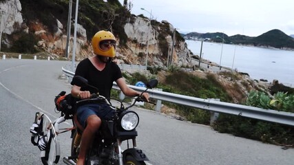 Vietnam road trip on motorbike, man travels seaside with kite surfing gear