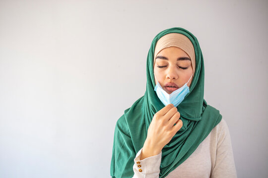 Arab Woman with protective face mask off and breathing fresh air. Concept of taking off the mask. Coronavirus over concept. Young woman take off protective mask. End of quarantine.