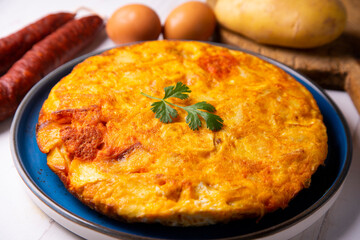 Traditional Spanish omelette cooked with chorizo, potatoes and onion. Traditional tapas of Spanish gastronomy.