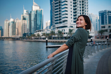 Fototapeta na wymiar Happy young female traveler in the big city of Dubai, UAE