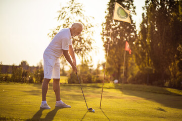 Fototapeta premium Senior man playing golf alone.