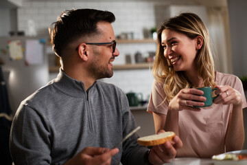 Husband and wife enjoying in breakfast. Loving couple drinking coffee in the kitchen.